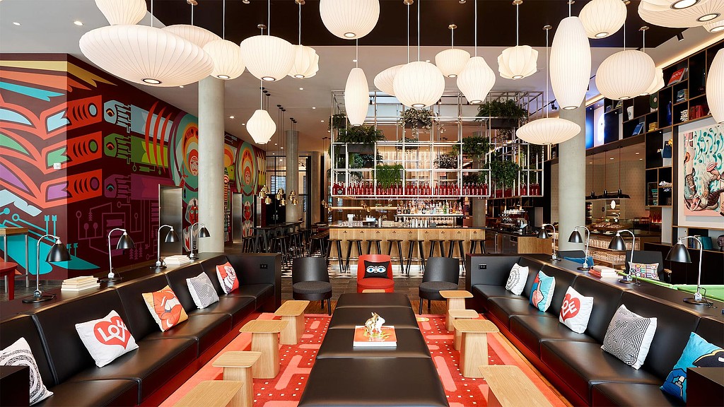 A room with a couch and chairs.