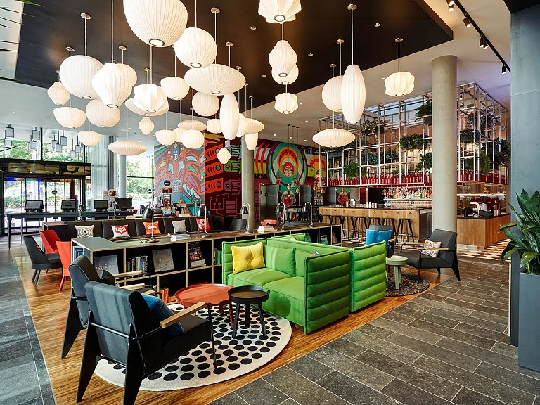 A room with a couch and chairs.