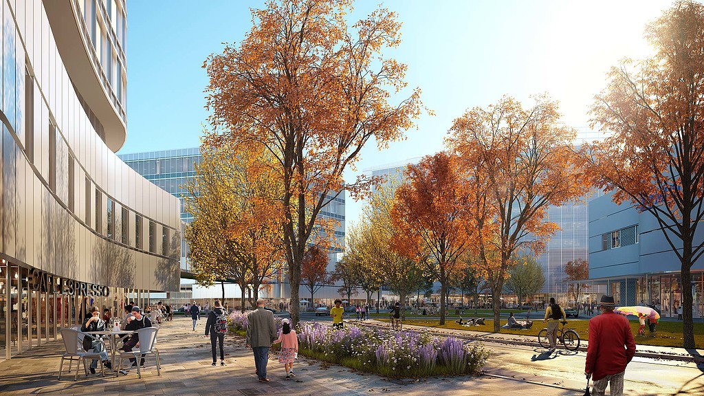 A group of people walking around a park with trees and buildings.