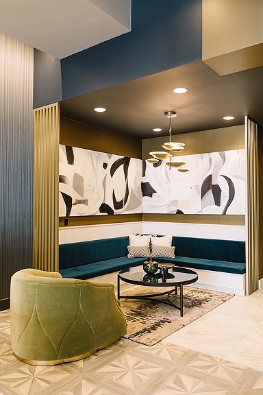A room with a couch and a table with a painting on the wall.