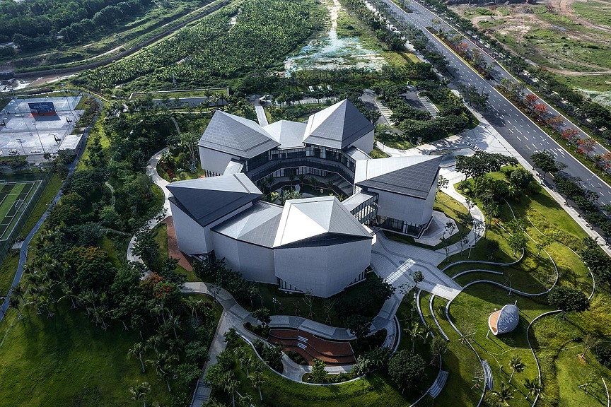 A building with a large lawn and trees around it.