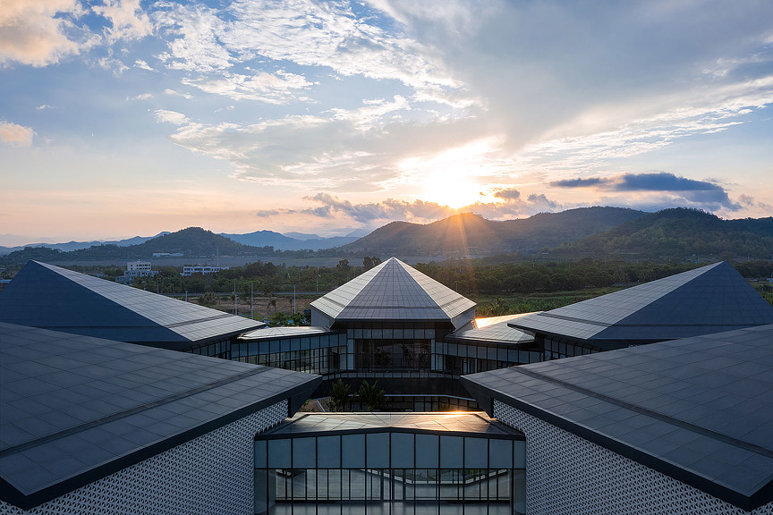 A building with a view of the mountains and the sun.