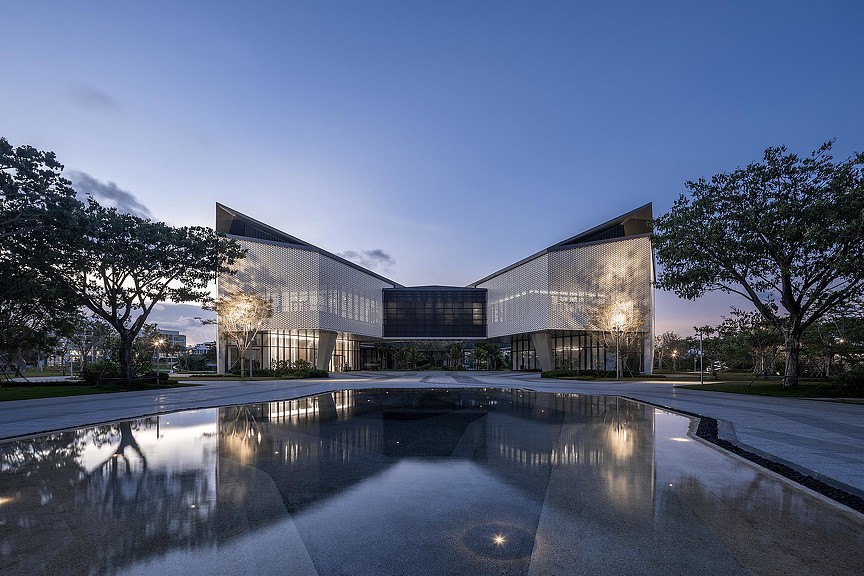 A building with a pool of water in front of it.