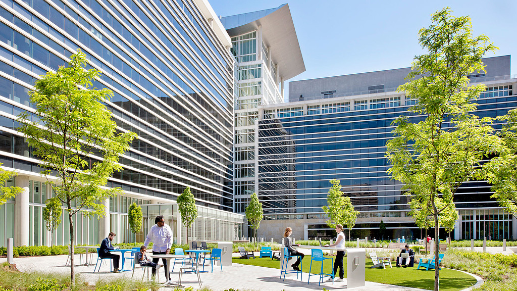 People sitting on benches in front of a building.