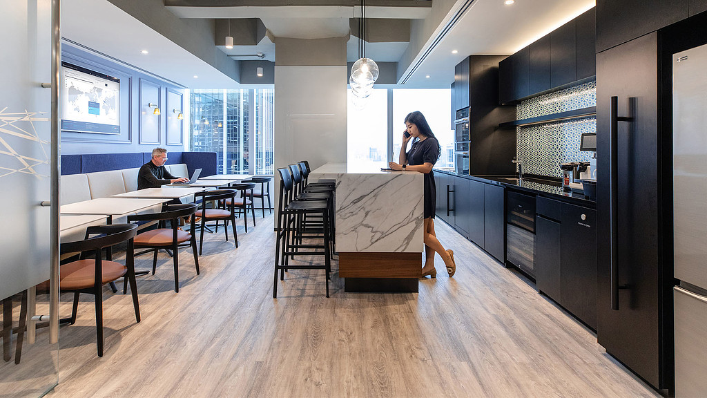 A person standing in a room with a table and chairs.