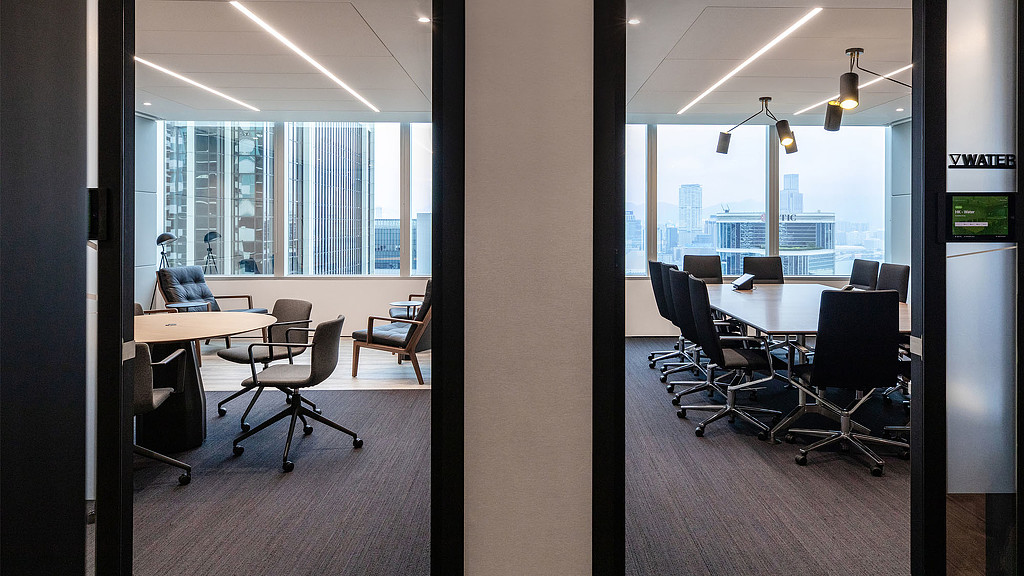 A room with a table chairs and a window with a view of a city.