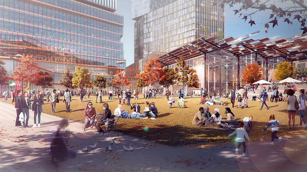 A group of people sitting on the ground in front of a building.