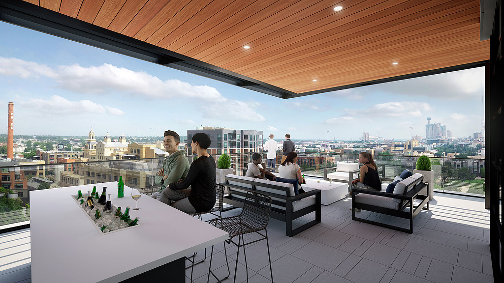 A group of people sitting on a deck with a view of a city.