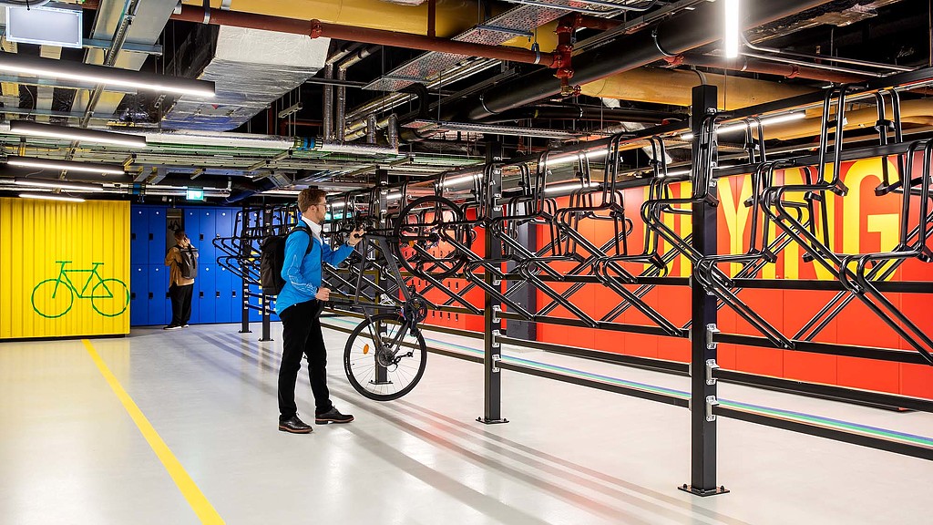 A person holding a bicycle in a bike shop.