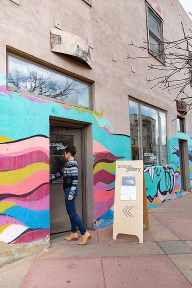 A person standing in front of a building with graffiti on it.