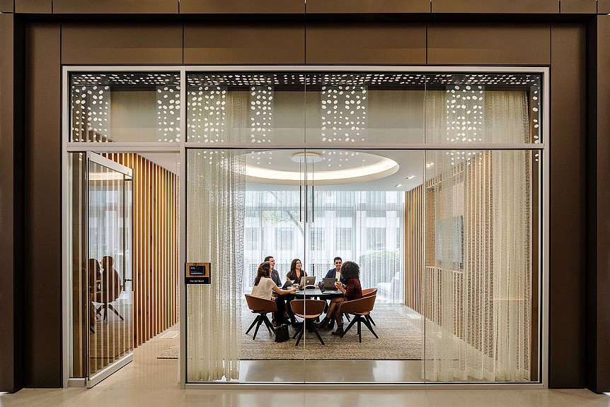 A group of people sitting at a table in a room with a large window.