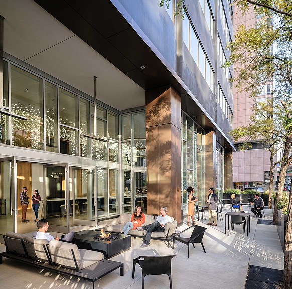 A group of people sitting on a bench in a large building.