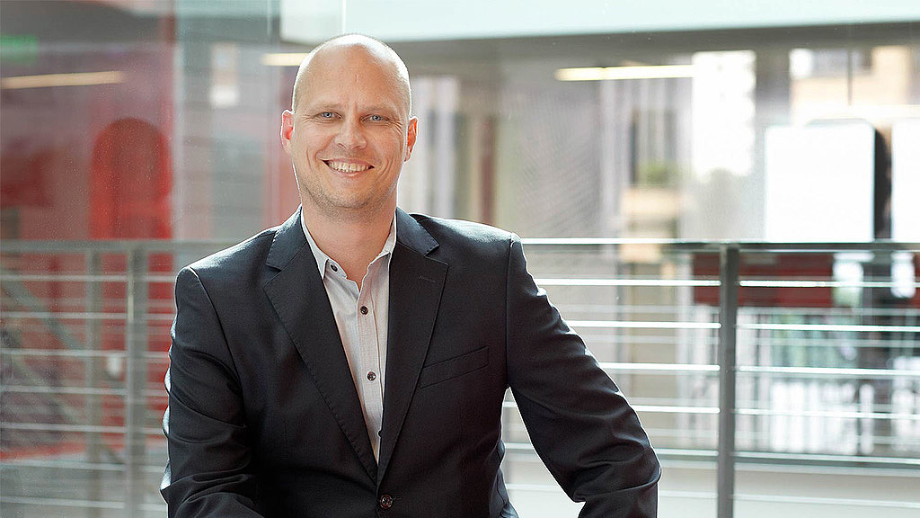 A man in a suit smiling.