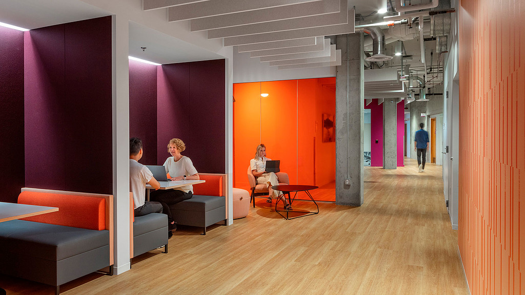 A group of people sitting on couches in a room with red walls.