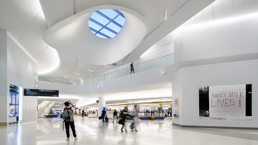 A group of people in a large building with a large white ceiling.