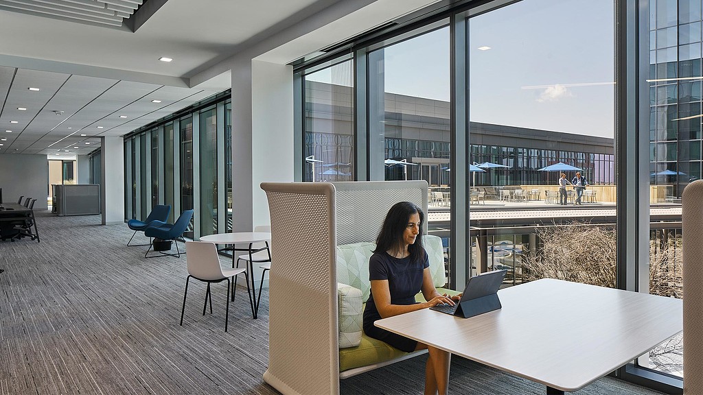 Woman working on tablet in open workplace seating
