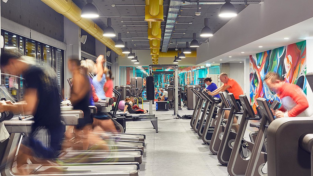 People using treadmills and exercise bikes in workplace gym
