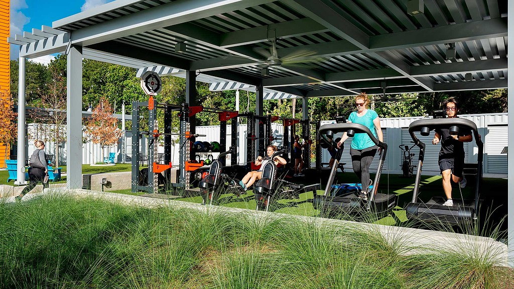 People working out in Holcomb Family YMCA outdoor fitness area