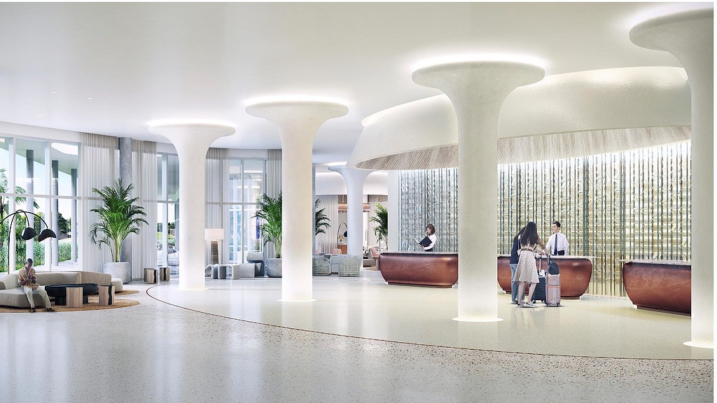 A group of people sitting in a large room with white pillars.
