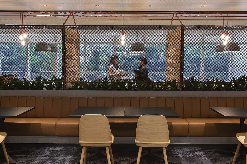 Two female employees talking in Standard Chartered Bank cafe.