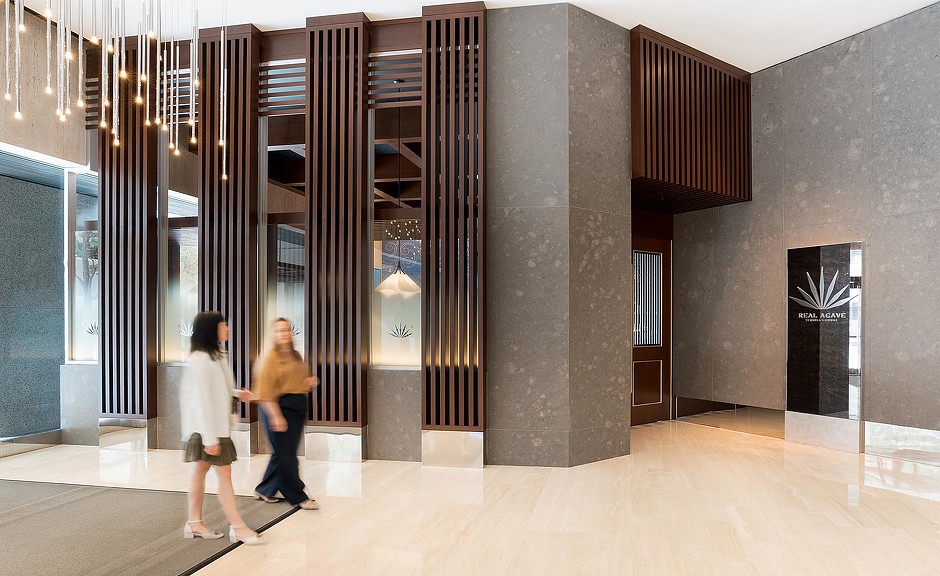 Two women walking in building lobby to Real Agave.
