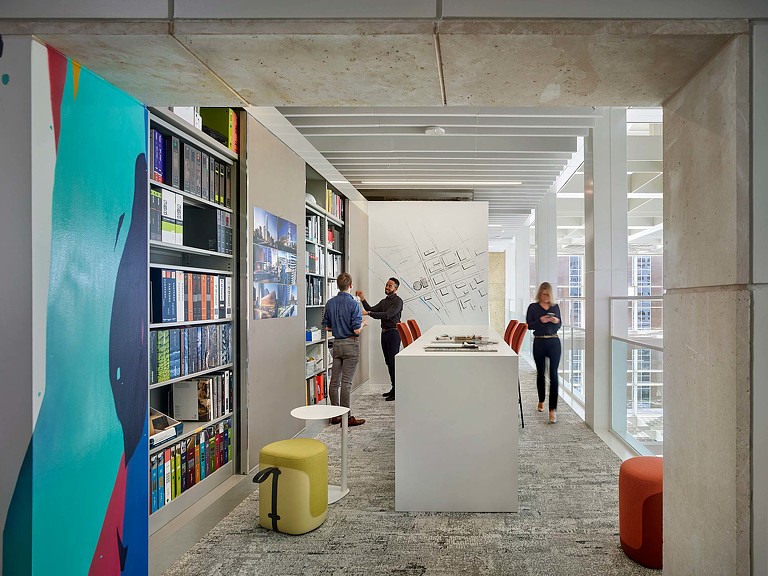 People in a room with shelves.