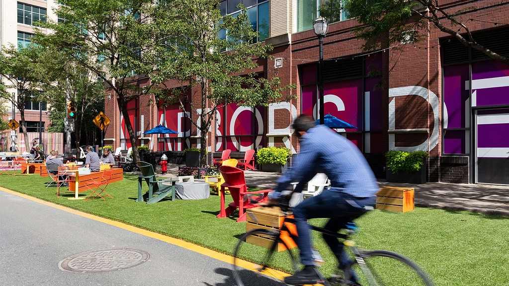 A man riding a bicycle in front of Harborside.