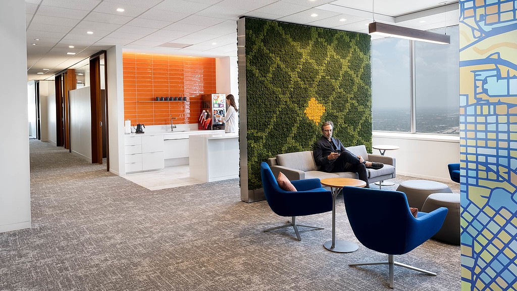 Akin Gump Houston lounge seating with carpeted green wall and cafe.