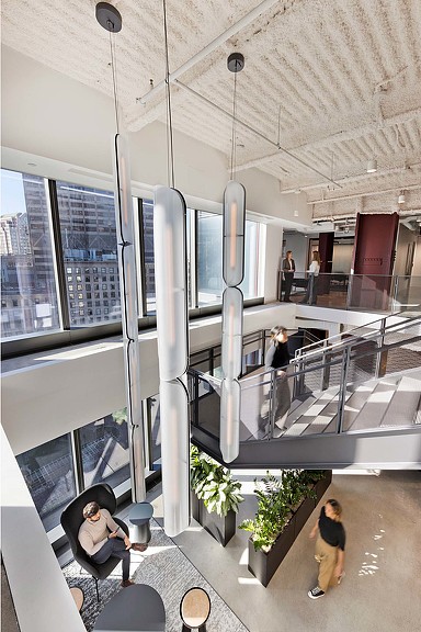 Open, double-height space with interconnecting staircase in the JLL workplace