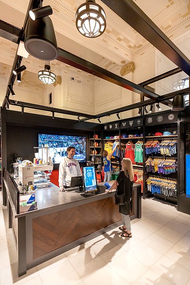 A woman checking out at NBA Sydney store register.