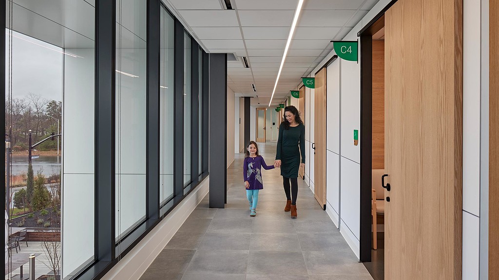 A mother and daughter walking through Mass General Brigham iCare hallway