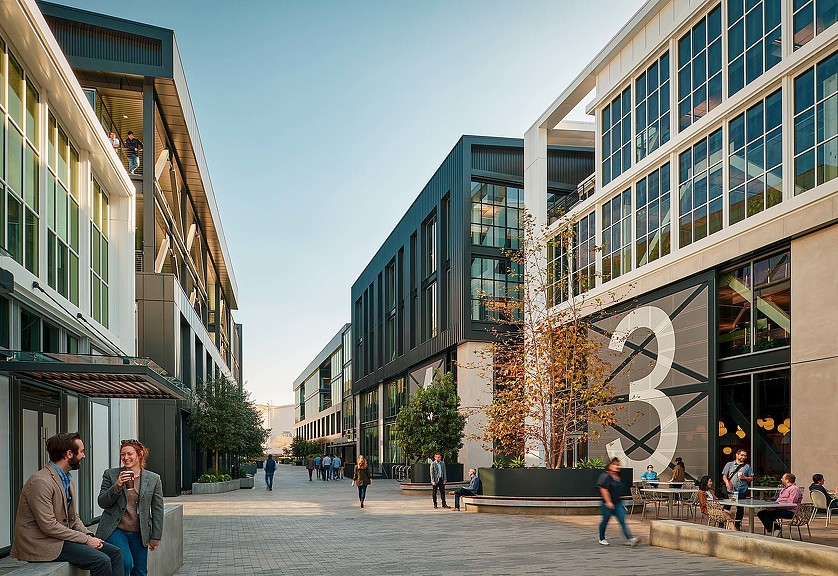 People sitting on benches outside of a building.