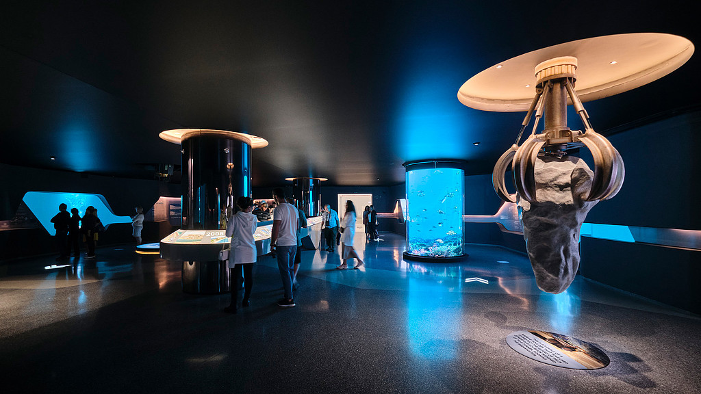 A group of people standing around a large sculpture.