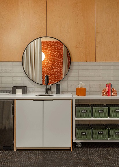 A kitchen with a round mirror.