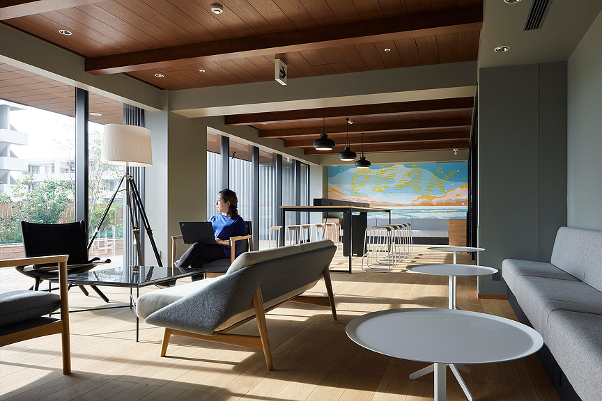 A woman working on her laptop at The Peak Sapporo office lounge