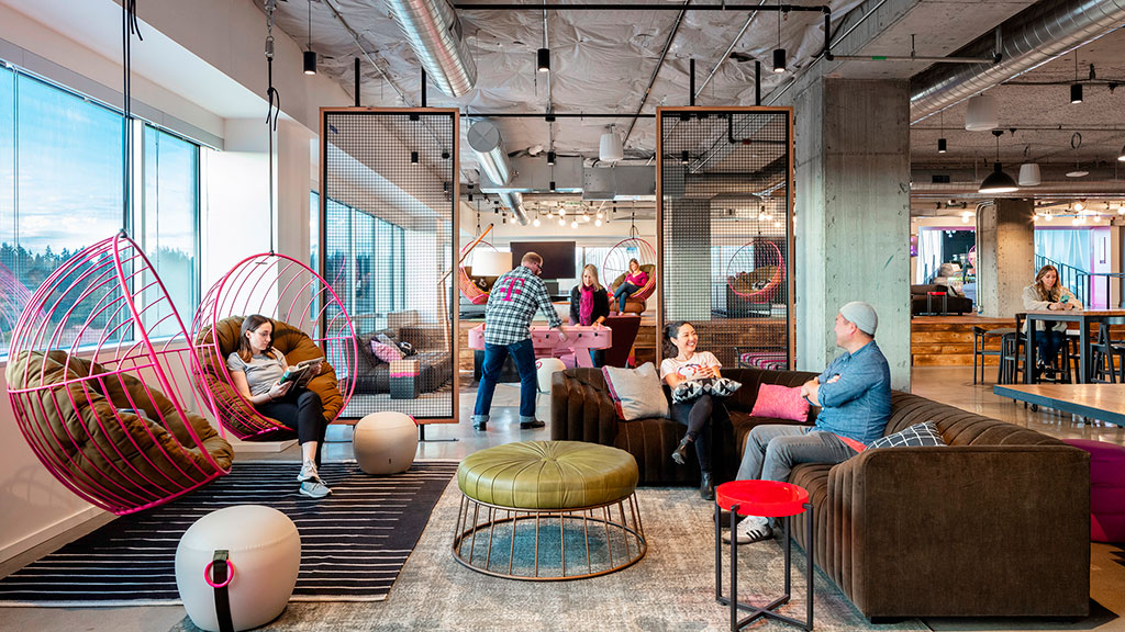 A group of people sitting in a room with a large glass wall.
