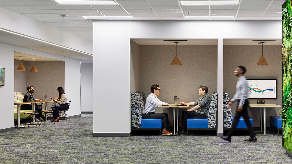 A person standing in front of a group of people sitting at a table.