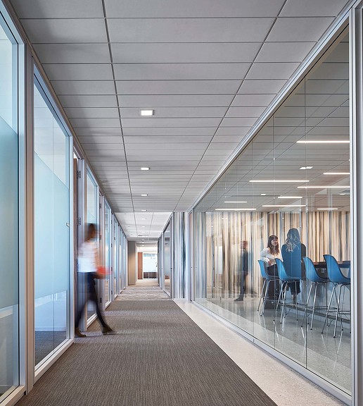 A long hallway with people sitting at tables.