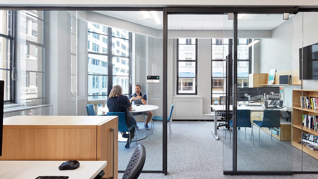 A man and woman sitting at a table in a library.