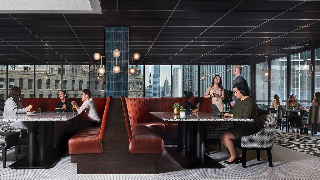 A group of people sitting around a table in a dark moody amenity area at Voco Holiday Inn