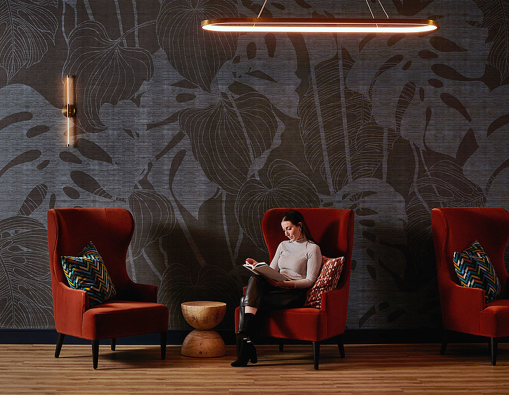 A person sitting in a chair in a boutique seating area at Voco Holiday Inn