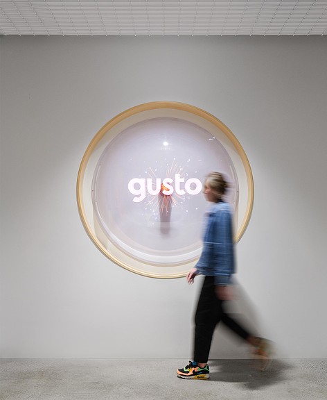 Woman walking by Gusto logo wall art