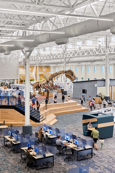 A large room with people and a large dinosaur skeleton.