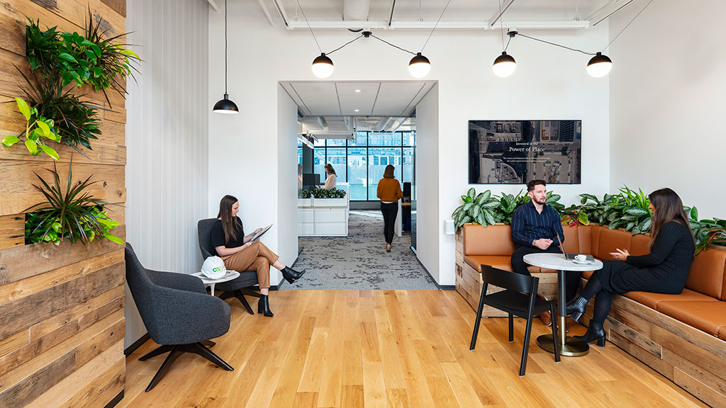 A group of people sitting in chairs in a room with a wood floor.