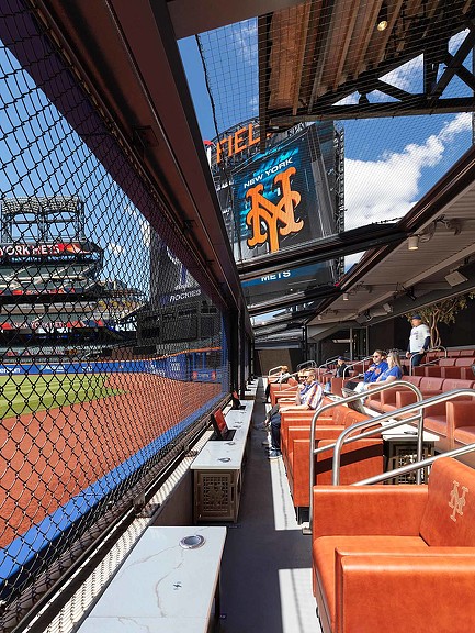 Inside of a stadium with a large screen and seats.