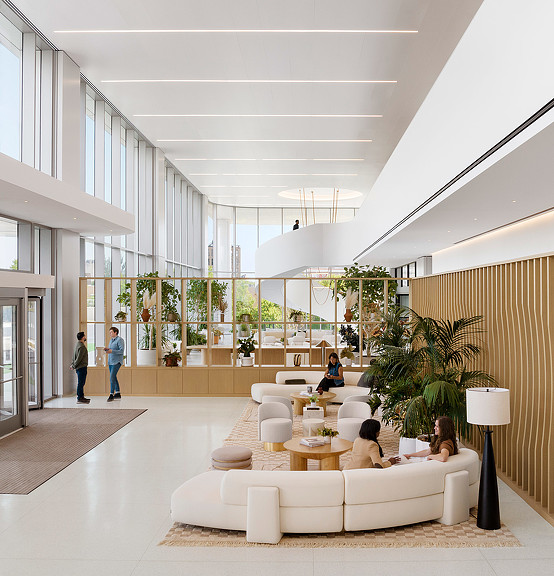 A room with a large white ceiling and a group of people sitting on a couch.