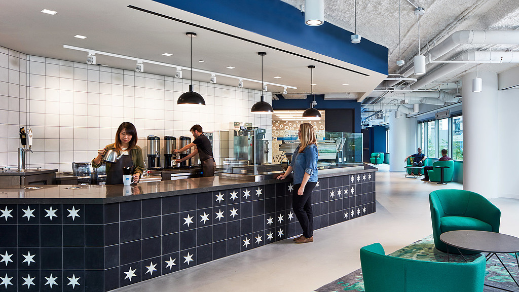 A cafe counter brightly lit in a modern office workspace