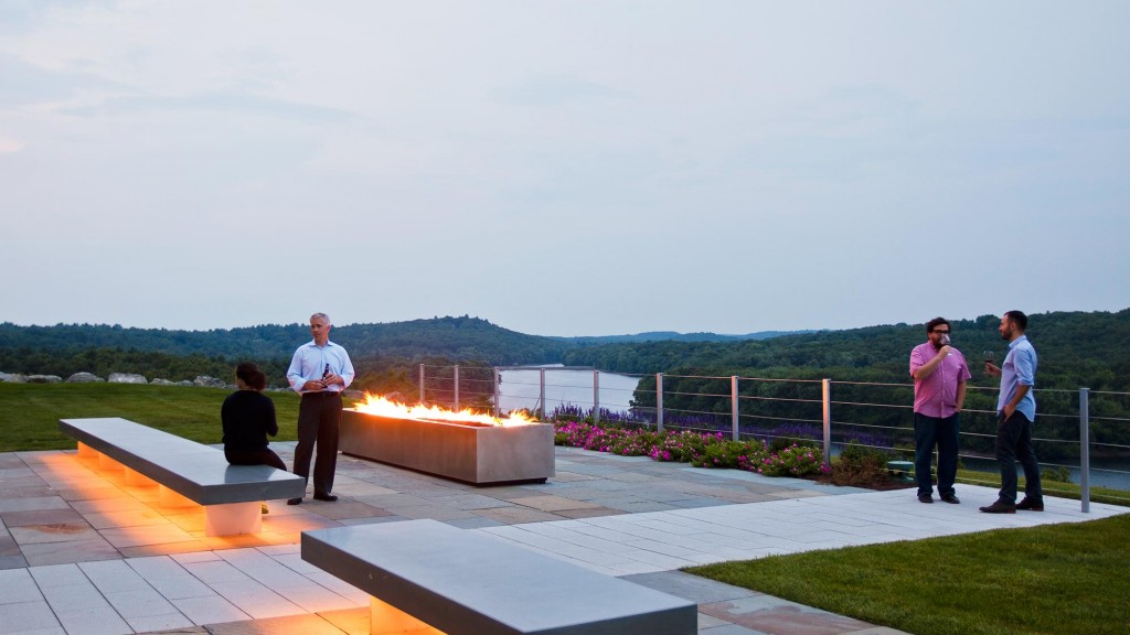 A group of people standing around a fire pit.