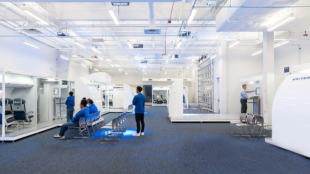 People in a room with white walls.