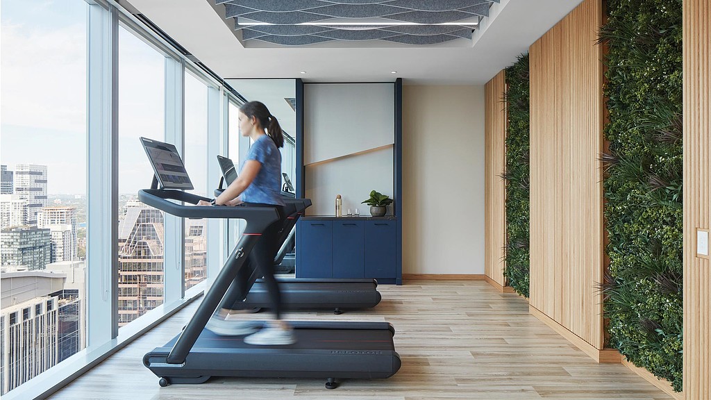 A person working out on a treadmill in a room with a window.